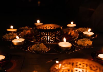 Rows of lit oil lamps and marigold flowers arranged for a festival of lights celebration