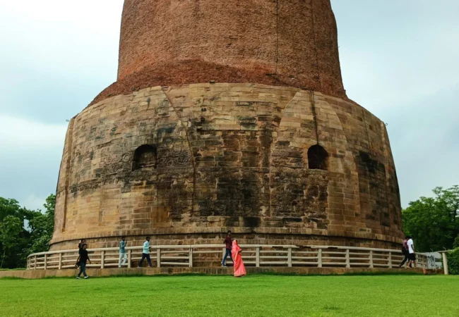 Dhamek Stupa in Sarnath with visitors on the surrounding lawn