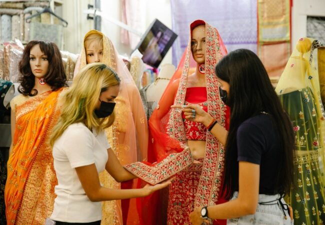 Shoppers comparing embroidery and fabric in a traditional clothing shop