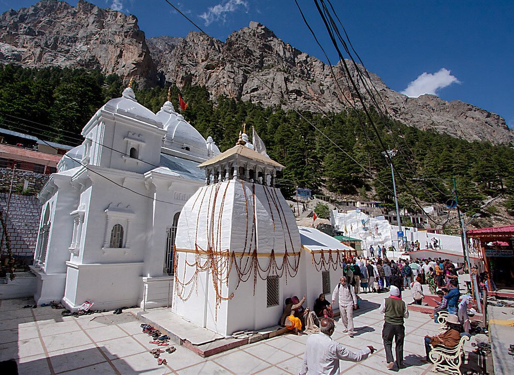 The white Gangotri Temple with pilgrims and rocky Himalayan slopes behind, Uttarakhand